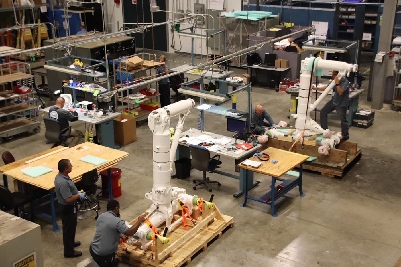 Workers in a warehouse working on landing gear.