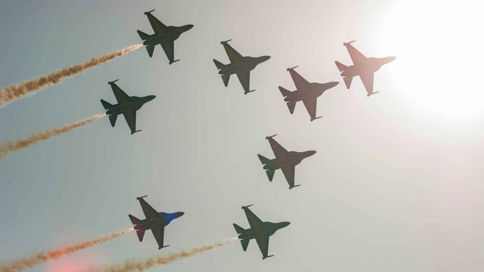 Silhouettes of eight T-50 jets up in the air, flying in formation