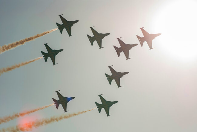 Silhouettes of eight T-50 jets up in the air, flying in formation
