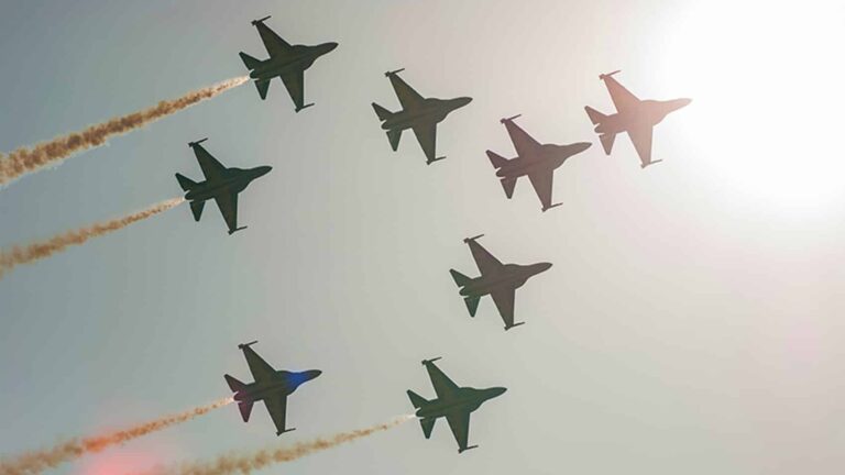 Silhouettes of eight T-50 jets up in the air, flying in formation